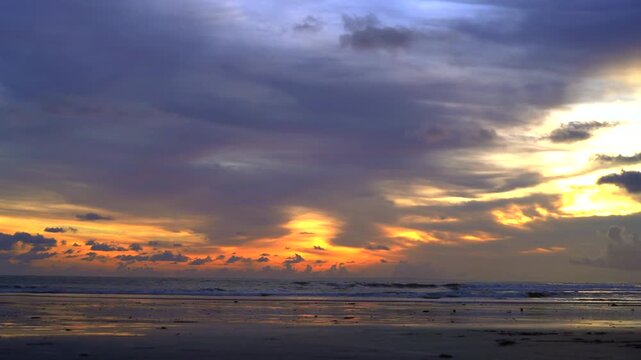 Dramatic sunset over Kelating Beach with colorful clouds and waves