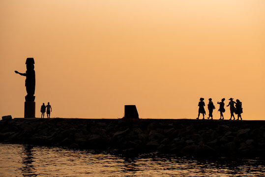 A sunset walk to a totem pole with a group in sillouette