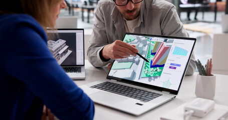 Naklejka premium BIM Specialist Reviewing City Property Maps