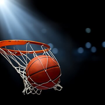 Basketball going through hoop with white net and orange rim under spotlight