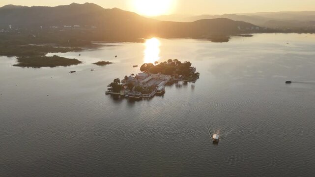 Aerial orbit around island palace on Lake Pichola at sunset in Udaipur India