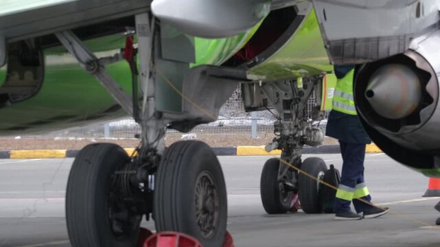 Airplane. Airport terminal technician worker man airline maintenance ground crew aircraft. Preparing for departure. Safety.