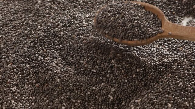 close up of schia seeds scoop with a wooden spoon food texture and background