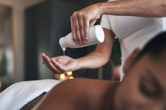 Therapist, client or hands with oil for massage, deep tissue treatment or muscle relaxation therapy. Bottle, stress relief or masseuse with person in wellness clinic, body care product or healing spa