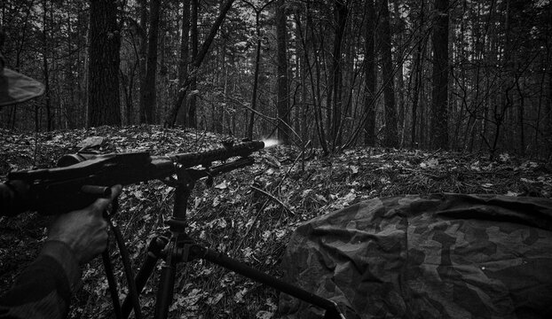 Wehrmacht machine gunner firing MG34 in forest trench during WWII battle