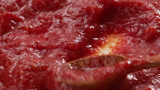 close up of red tomatoes sauce mixing with spoon food texture
