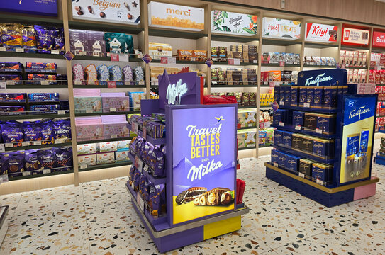 Changi, Singapore - Jan 14, 2026: A vibrant duty-free retail section featuring Milka, Cadbury, and Karl Fazer chocolate displays inside the Changi Airport departure terminal.