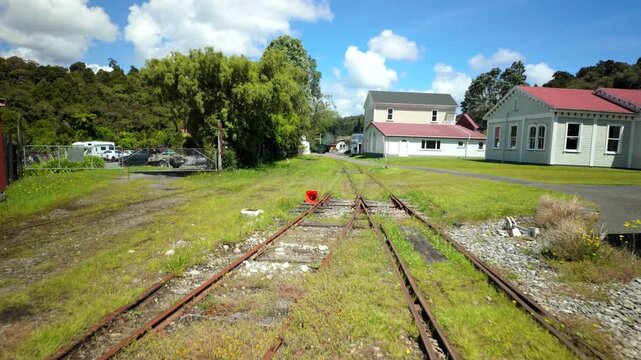 Walking Along Historic Railway Tracks Toward Village Buildings