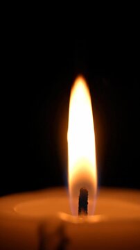 Single candle flame burns calmly in dark space creating a peaceful spiritual background for remembrance meditation hope and warm minimalist designcandle