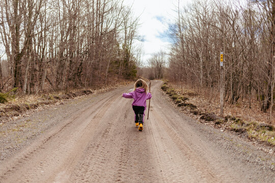 Playful child running and jumping on a spring hike