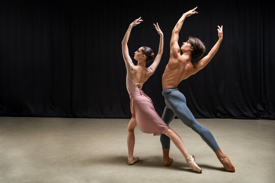 Ballerina and ballet dancer performing duet on stage.