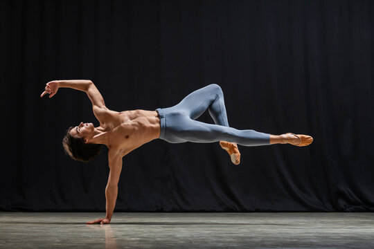 young athletic ballet dancer performs complex choreography on stage.