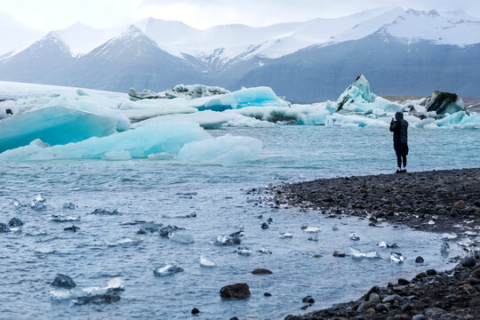 Guy takes pictures of the iceberg and the whole glacier in Icela