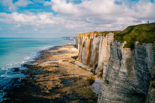 Cliffs and coast view at Etretat with bright skies and calm waters