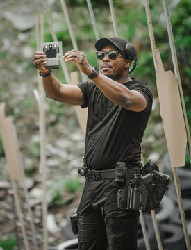 Man inspecting a target at an outdoor shooting range