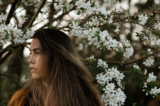 Profile of young woman surrounded by white blossoms
