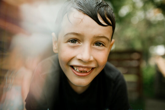 Portrait of a happy young boy with wet hair smiling outdoors