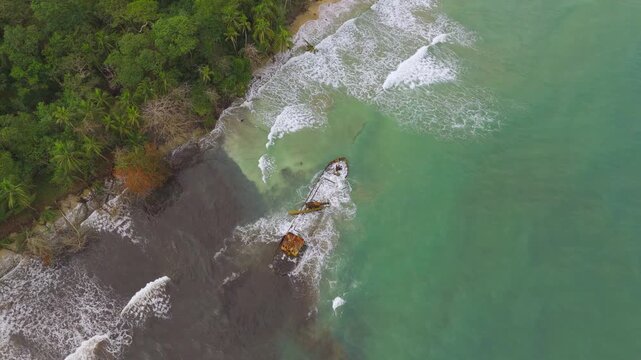 Drone shot of Yicel shipwreck. Huge waves crash around vessel. Lone fisherman throws net. Costa Rica.Playa Grande in Manzanillo.