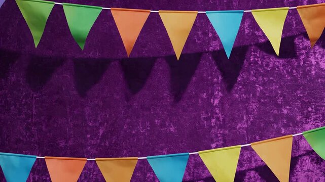 Banderines de colores ondeando sobre pared p&uacute;rpura texturizada, decoraci&oacute;n festiva para Cinco de Mayo, fiesta mexicana, celebraci&oacute;n de cumplea&ntilde;os y eventos culturales alegres.
