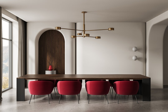 Modern dining room interior with long wooden table, vivid red chairs, arched wood niche, gold chandelier and soft neutral walls in elegant contemporary architecture. 3D Rendering