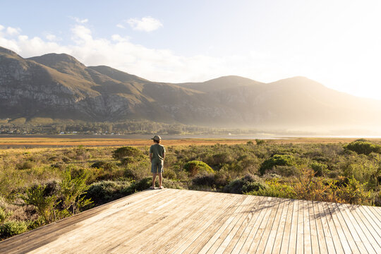 young boy looking out at sunrise, lagoon and Klein Mountains, Stanford, South Africa