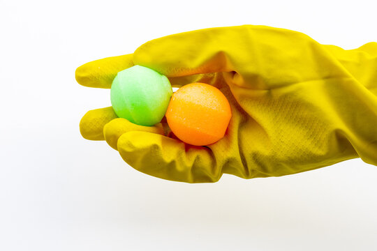 Hands in Yellow Rubber Gloves Holding Colorful Mothballs Isolated on White