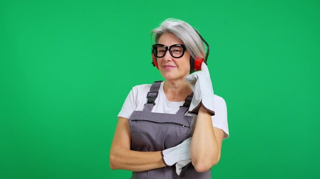 Mature female construction worker posing with earmuffs