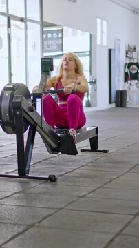 Determined athletic woman training on a rowing machine