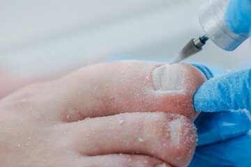 Fototapeta premium Close-up of toenail being filed at nail salon for male pedicure treatment