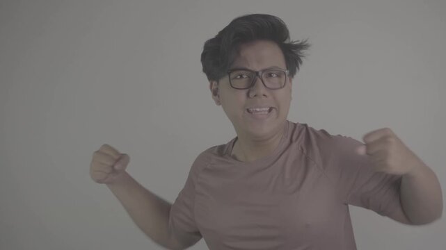 Southeast Asian person wearing brown jersey, raised his clenched fist in excitement S-Log3, S-Gamut3.Cine