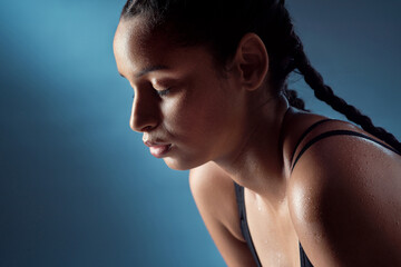 Fitness, tired or woman in studio with break, cardio fatigue or sweat in intense practice. Exercise, space or athlete on blue background with rest, training burnout and recovery for performance goals © peopleimages.com