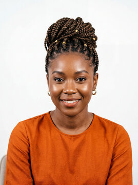 Close-up of a woman with braids and a vibrant orange blouse