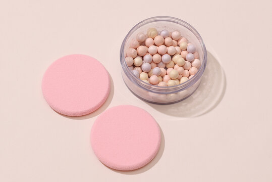 Makeup sponge pads and powder balls on beige background. Beauty products