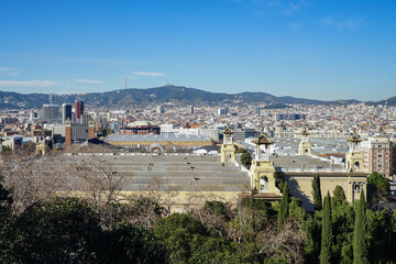 Obraz premium Plaza de Catalunya,Barcelona,Spain,Panoramic view of a cityscape with historic buildings and surrounding hills under a clear blue sky