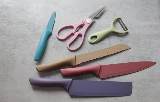 Kitchen scissors and vegetable peeler, set of knives on a concrete countertop