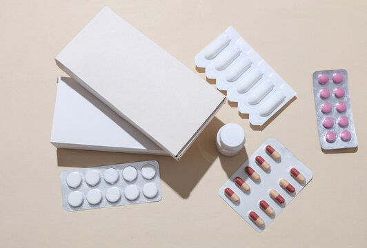 Mockup of medicines with boxes on beige background with shadow. Flat lay. Top view
