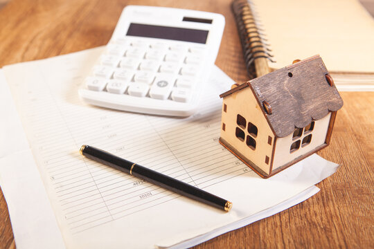 house calculator and pen on table on white background. real estate loan concept