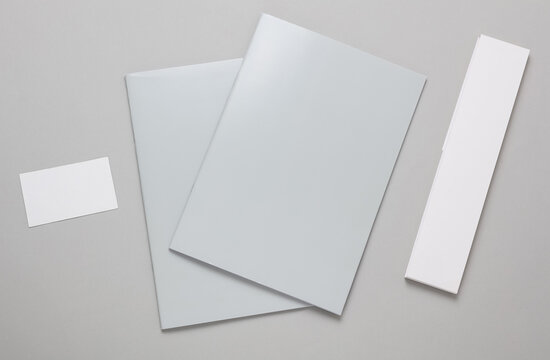 Corporate business books or magazines with business card on gray background. Mockup for design