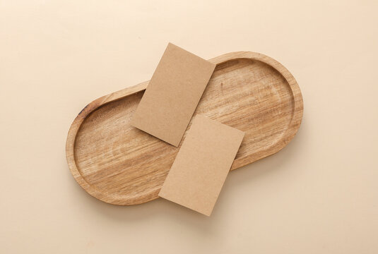 Craft business cards in Natural wooden tray on beige background