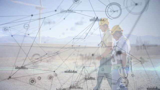 Two technicians walking toward wind turbine, initiating animated nodes monitoring turbine data