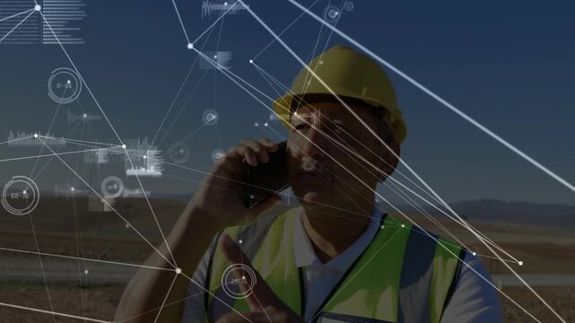 Construction tech receiving call and pointing while directing crew with HUD linking him to horizon