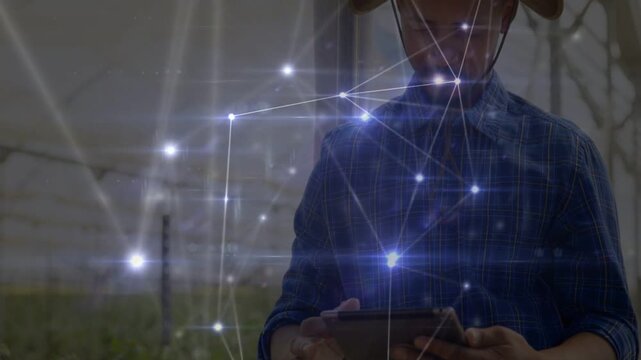 Vertical video: Field tech tapping tablet, causing nodes glowing while monitoring greenhouse crops