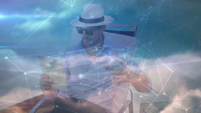 Man tapping tablet to check tech data, picking up round object while cloud overlay obscuring view
