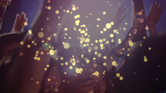 Concert crowd cheering, raising hands to backlight while gold particles drifting, revealing bands