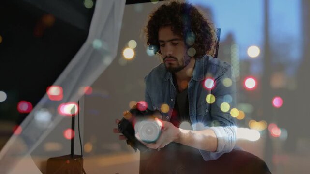 Male photographer inspecting camera mounting lens confirming setup while bokeh overlay persisting