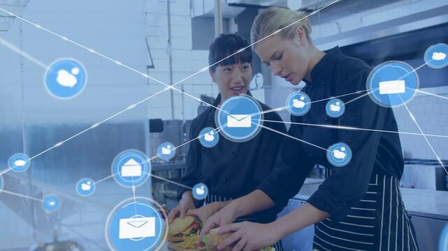 Vertical video: Two chefs plating meals in kitchen, envelope icon creating blue overlay for service