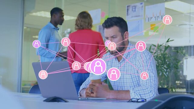 Seated man typing at laptop, causing pink nodes clustering around desk, showing business network