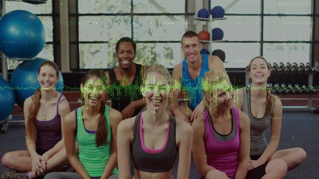 Seven fitness peers sitting in gym, waveform scanning torsos and initiating thumbs-up near balls