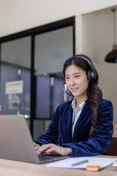 Young asian woman providing online customer service with laptop