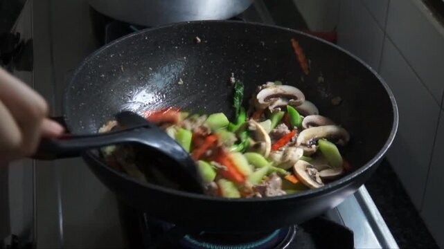 Second step cooking authentic Thai Pad See Ew on home stove. Stir fried in a hot pan with tender marinated pork, carrot, Chinese broccoli and mushroom (Optional)